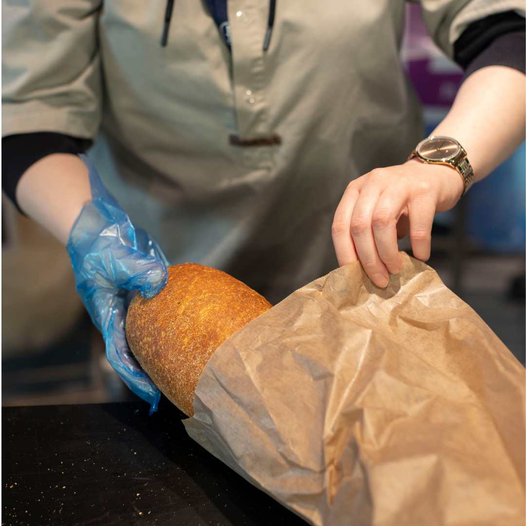 Personaler står og pakker et brød